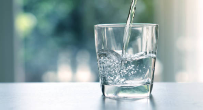 Water is being poured into a transparent glass